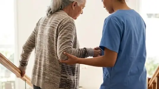 Cuidadora ajudando idosa a descer a escada